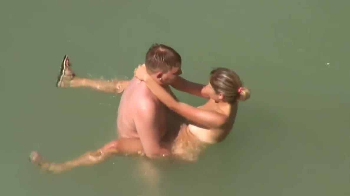 Couples enjoy beach sex in the water while they think no one is watching